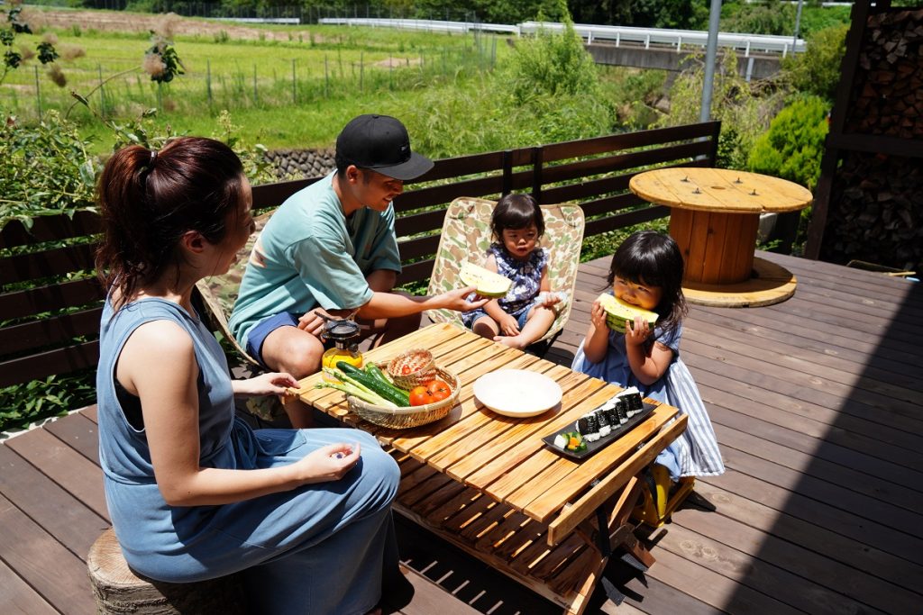 アウトドアリビングで食事を楽しむ家族