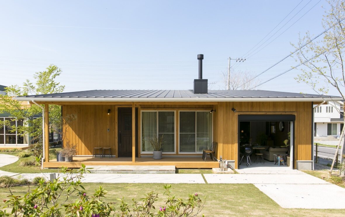 木の外壁と深い軒、庭へつながる平屋の住まい